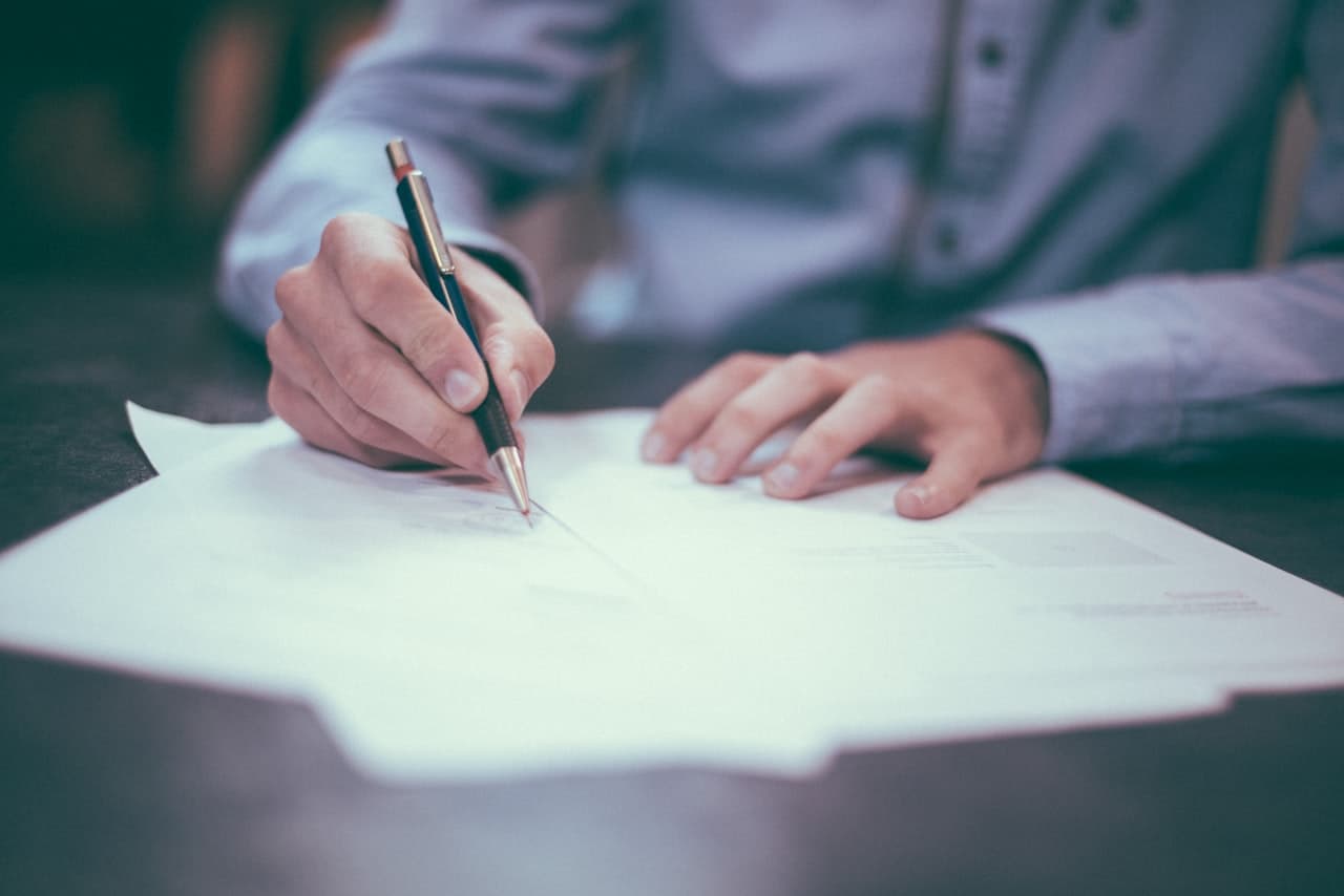 Doi profesioniști revizuind împreună un contract pe tabletă